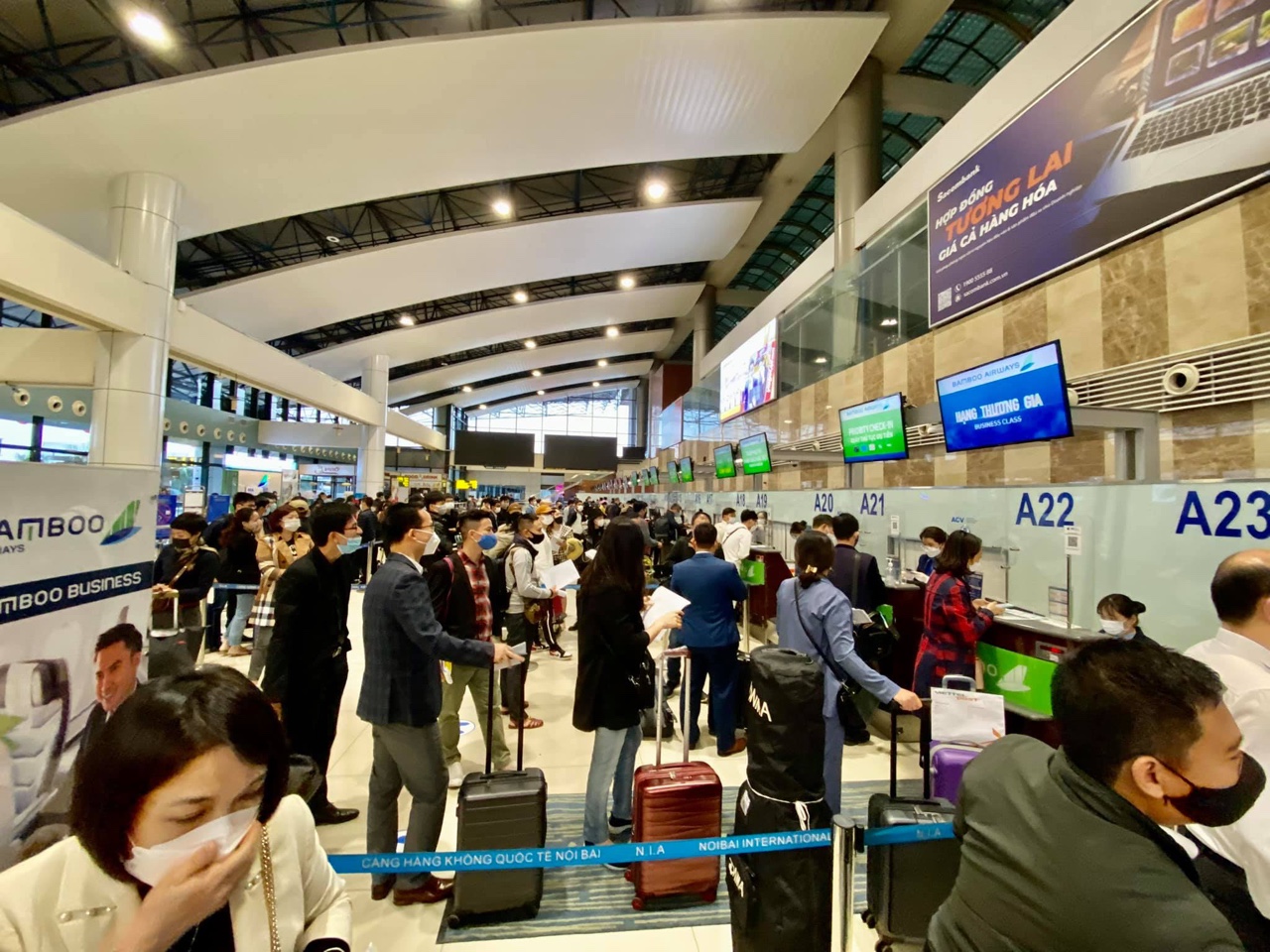 Hành khách xếp hàng trước các quầy làm thủ tục của Bamboo Airways tại sân bay Nội Bài sáng 23/10/2021.
